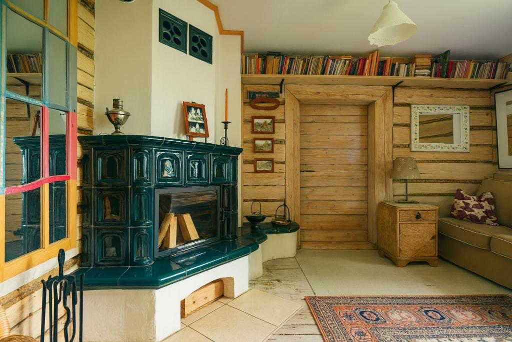 a living room with a green fireplace in a room at Chatka Koniaków 7 in Koniaków
