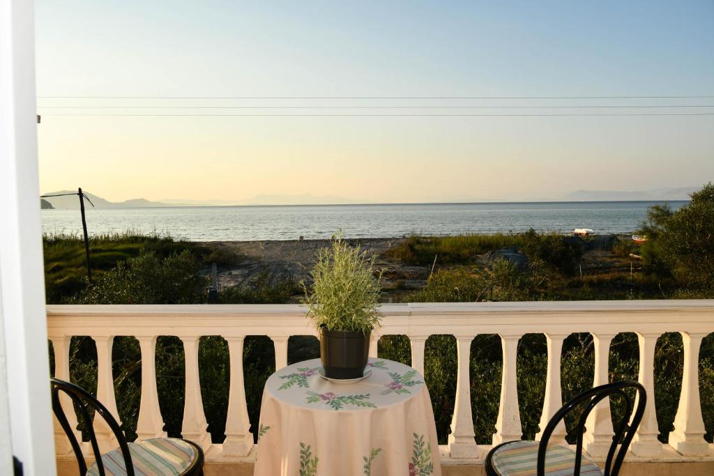 a table and chairs on a balcony with a view of the ocean at Barbara's Beach House in Lefkímmi