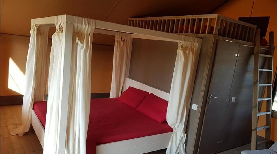 a bedroom with a bunk bed with red pillows at Village Glamping Biscione in Petrosino