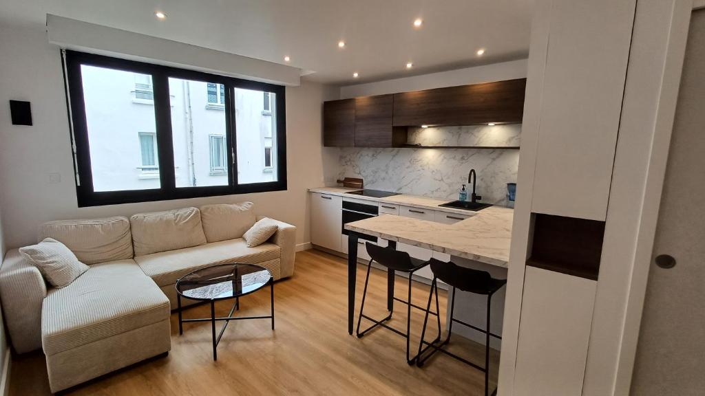 キブロンにあるAppartement proche de la grande plageのソファとテーブルのあるキッチンとリビングルーム