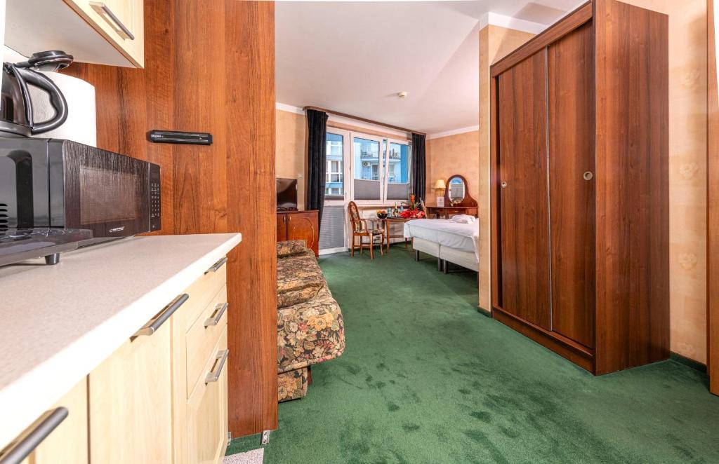a kitchen with green flooring and a living room at Apartamenty BLACK PEARL in Kołobrzeg