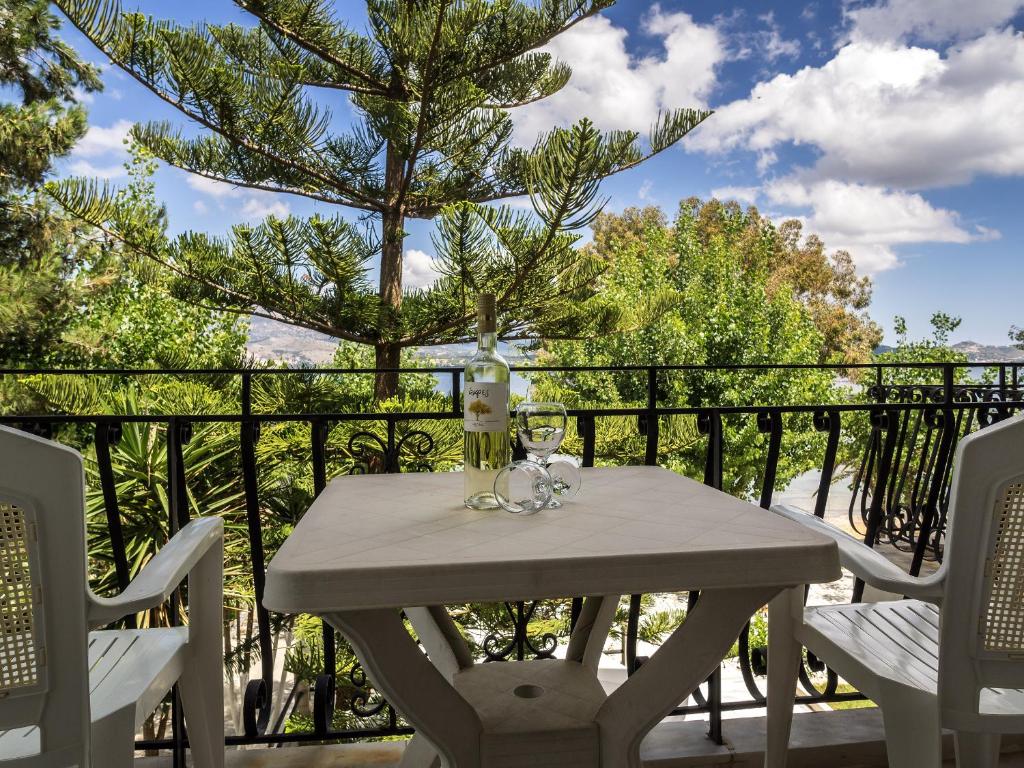 una mesa blanca y sillas en un balcón con un árbol en Sea Breeze Apartments, en Lixouri