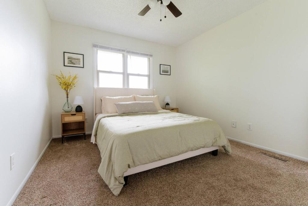 a white bedroom with a bed and a window at 5 Min to Adventureland and Casino - Fenced in yard in Altoona