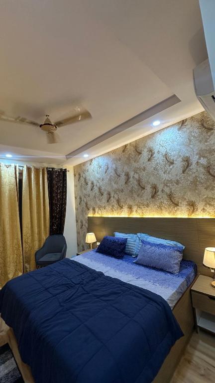 - une chambre avec un lit bleu et un mur dans l'établissement Luxurious kaveri, à Greater Noida