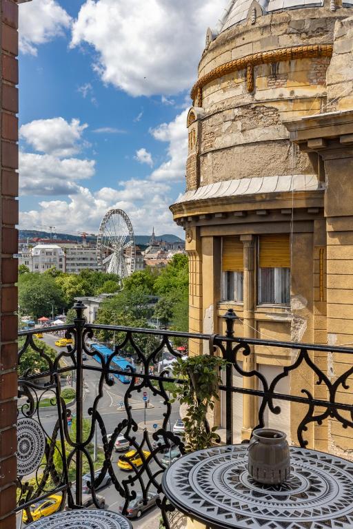 a table on a balcony with a view of a city at TOP Location Studio at Deák Sqr in Budapest