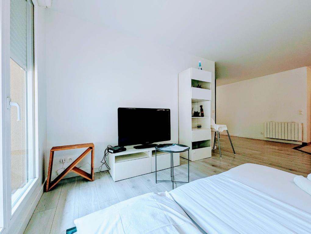 une chambre avec un lit et une télévision à écran plat dans l'établissement Chic and spacious apart with parking and garden, à Saint-Denis