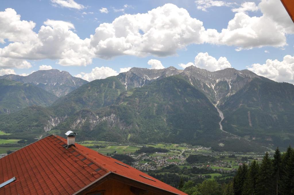 a view of a mountain range with a red roof at Almen-Kräuter-Oberreiter in Dellach im Drautal