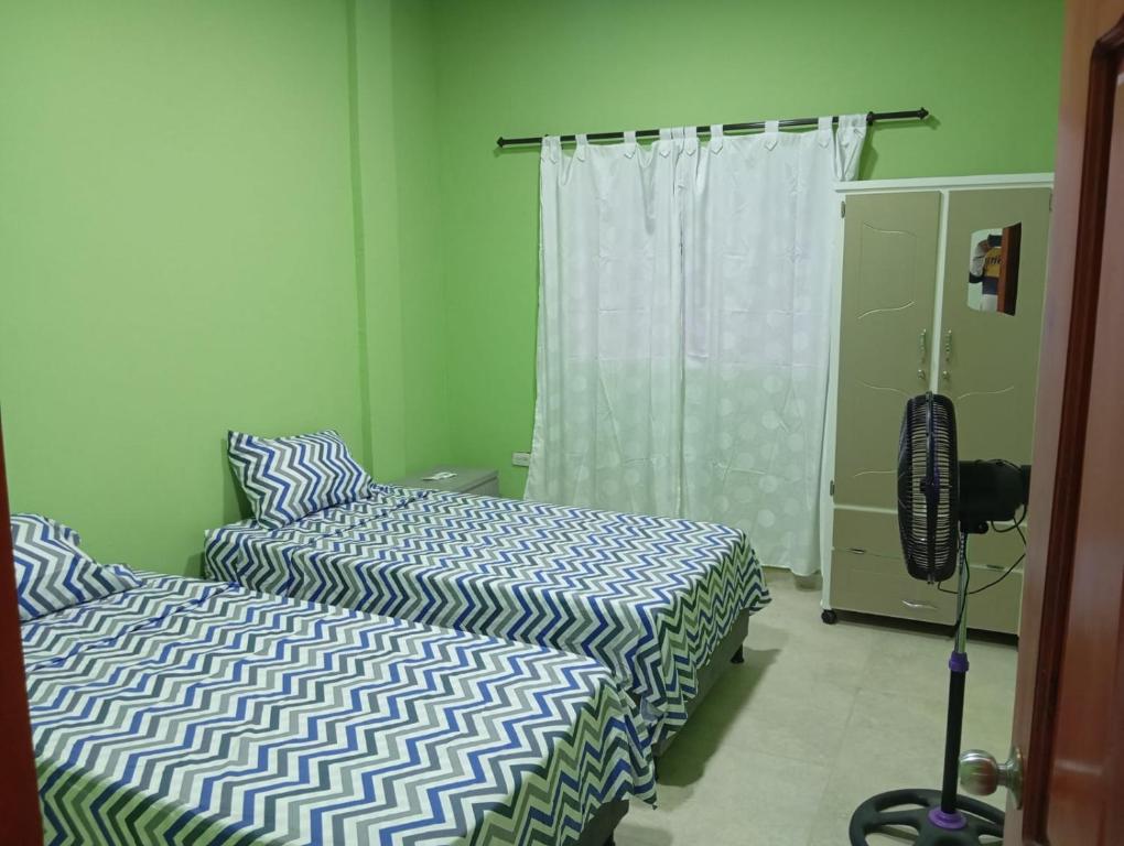 ein Schlafzimmer mit zwei Betten und einem Fenster in der Unterkunft Apartamentos el farol in Ciénaga