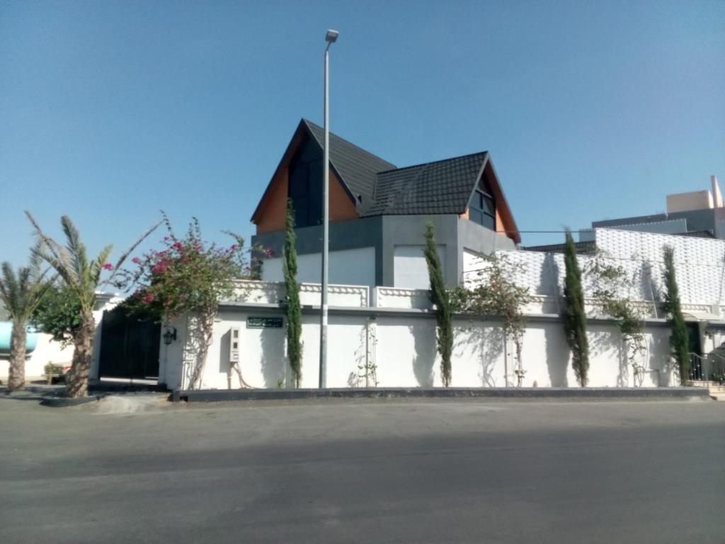 a white building with a fence next to a street at استراحة الشيوخ in Taif