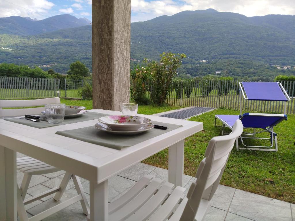 a white table and chairs with a view of mountains at Garden House in Sondrio