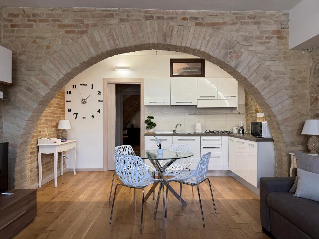 a kitchen and living room with a table and chairs at La Cripta - a due passi dalla Basilica - ItalyWeGo in Santa Maria degli Angeli