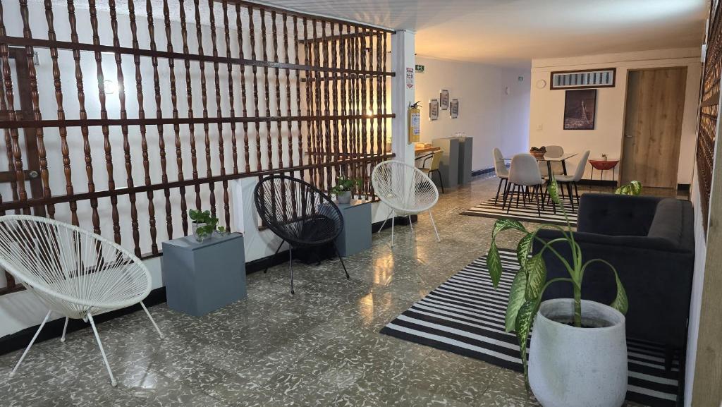 - un salon avec des chaises, un canapé et des tables dans l'établissement Hotel Casa Agena, à Carthagène des Indes