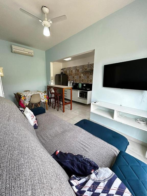 a living room with a couch and a flat screen tv at Recanto Salgando a Alma in Ubatuba