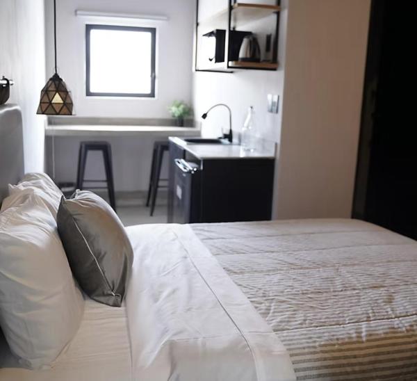 a bedroom with a bed and a kitchen with a sink at CoWork Hotel in Celaya