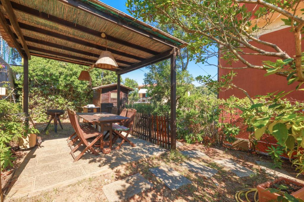 a patio with a wooden pergola and a table at Casa Lola - Goelba in Capoliveri