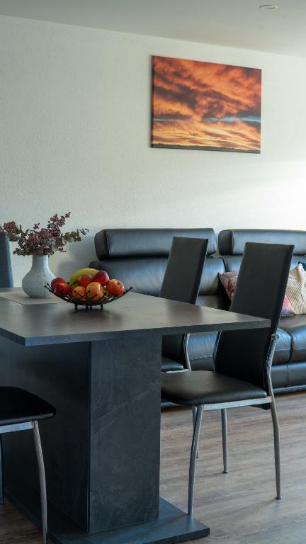 a table with a bowl of fruit and a couch at Black Forest Apartment in Friesenheim