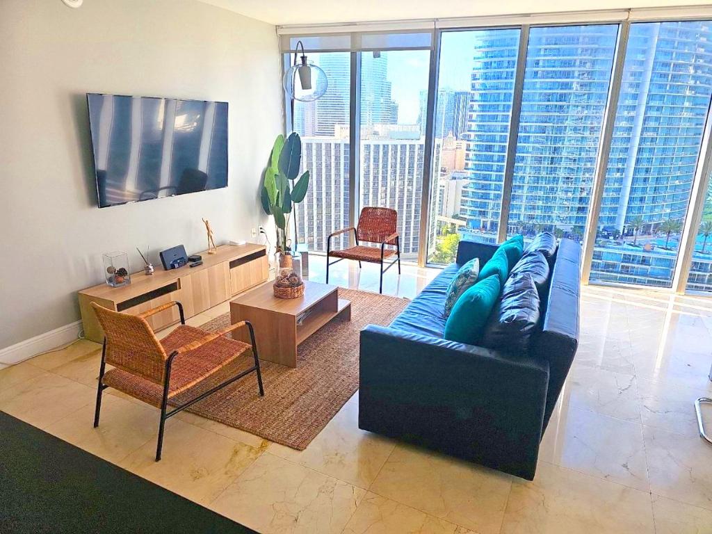マイアミにあるWonderful 2 BR Condo Icon Brickell With Poolの青いソファと大きな窓のあるリビングルーム