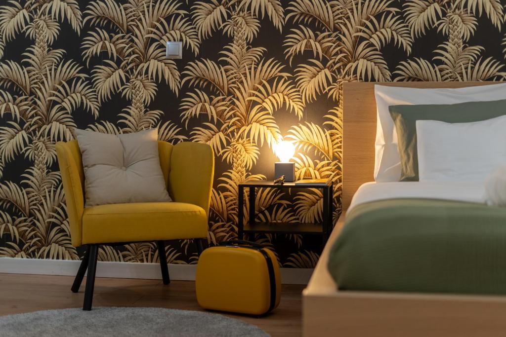 a bedroom with a yellow chair next to a bed at Old Town Luxe Retreat - King Bed - Steps to Main Square in Kraków