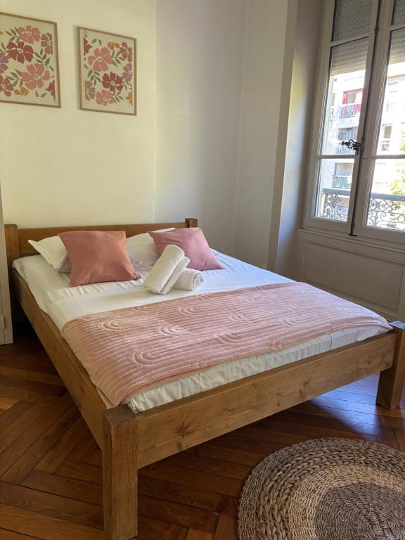 Cama de madera en habitación con ventana en Le Brottaux, en Lyon
