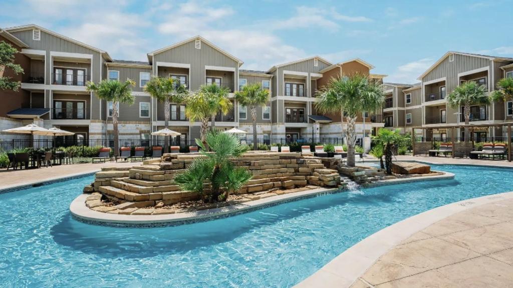 an image of an apartment complex with a swimming pool at Landing Apartments - New Braunfels in New Braunfels
