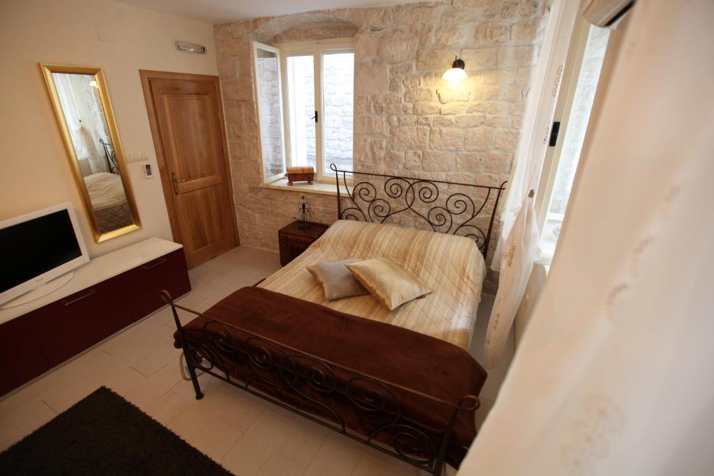 a bedroom with a bed and a television in a room at Tragurium & Salona Apartments in Trogir