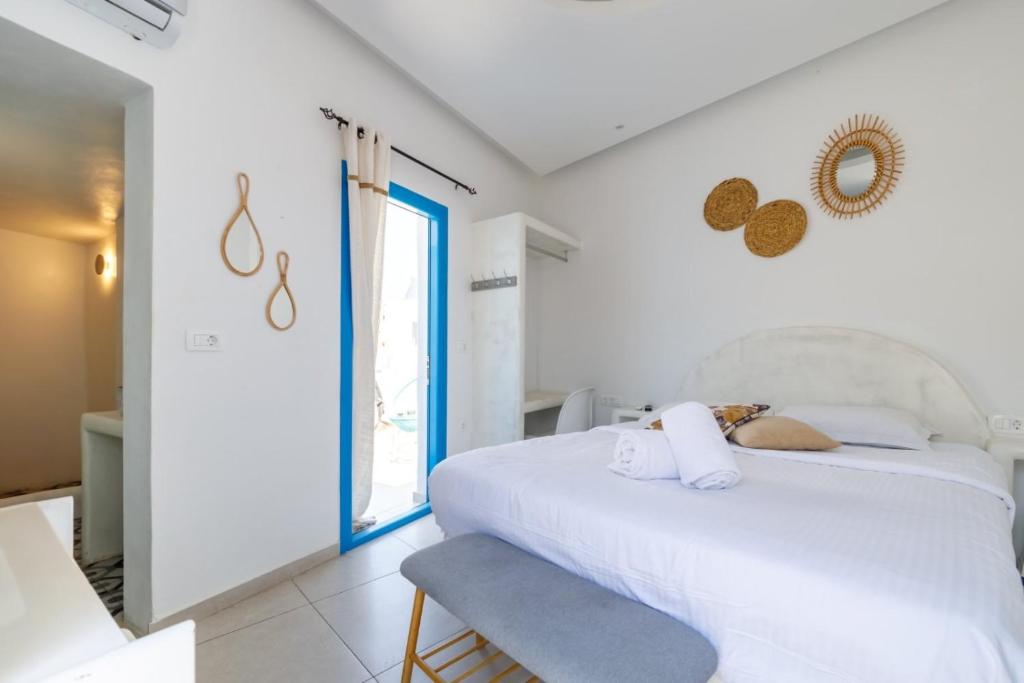 フィラにあるOldtown Suites Firaの白いベッドと窓のある寝室