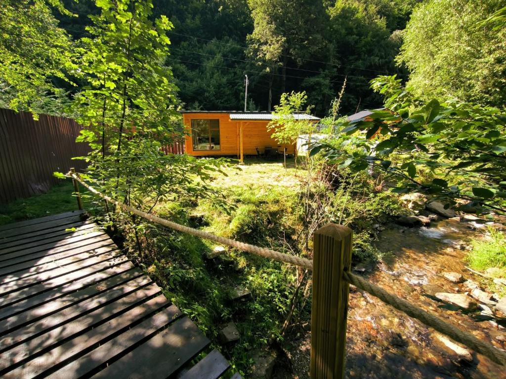 een klein huisje midden in een tuin bij Cabana Padurea Cerbilor in Moara de Pădure