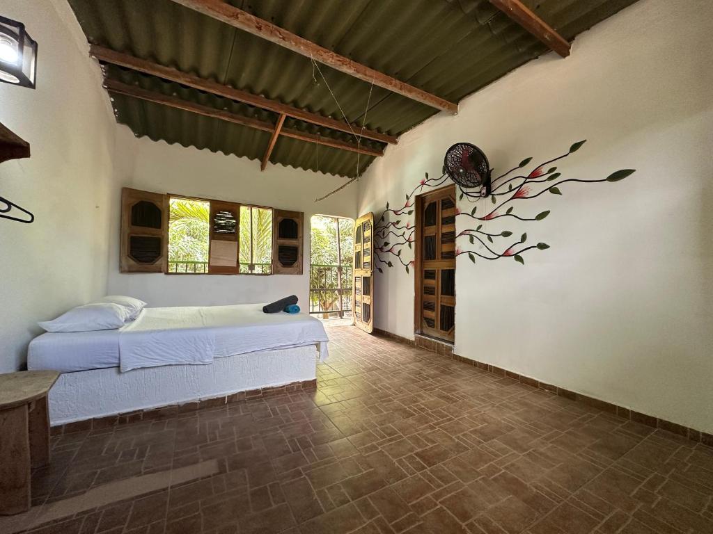 1 dormitorio con 1 cama y una planta en la pared en Hostal Luz de Luna, en Palomino