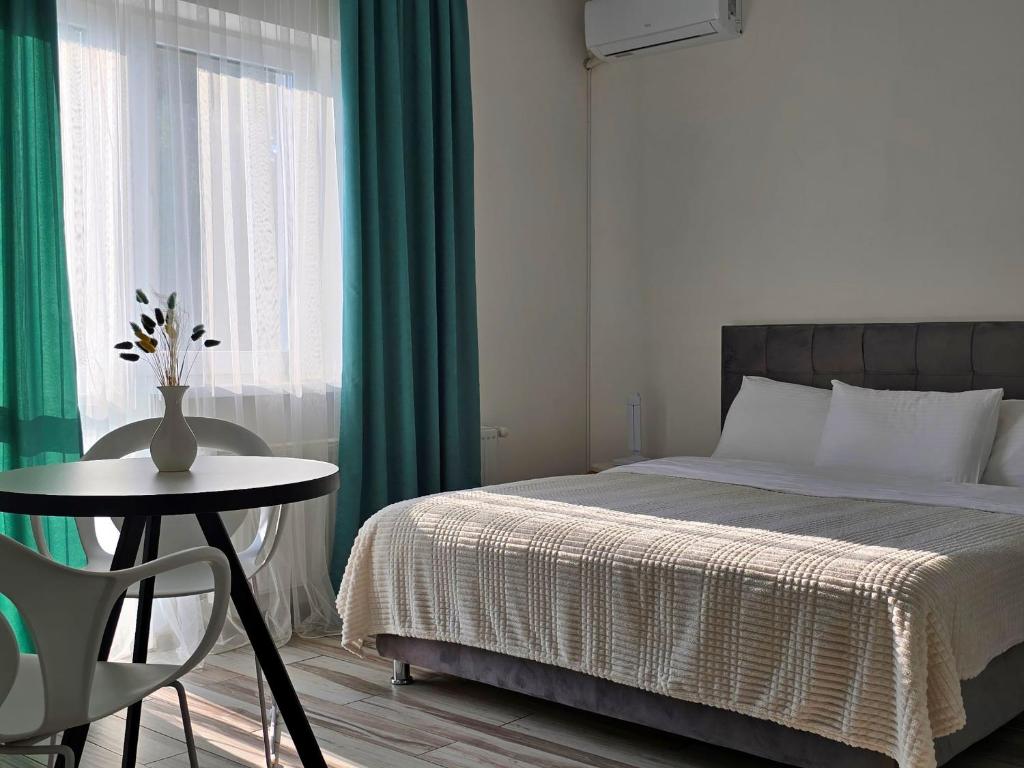文尼察TREND HOUSE Apartments的一间卧室配有一张床和一张桌子,上面有花瓶