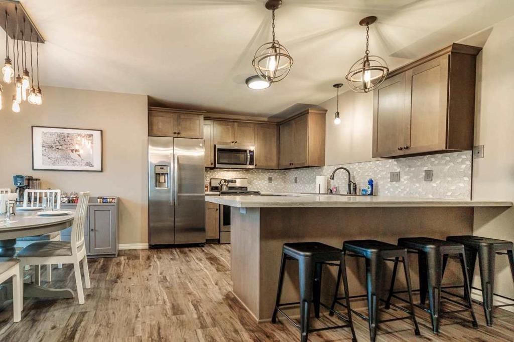 4Bedrooms 2 and 1 Half Bath Home for 9 Kid and Game Ready في غرين باي: مطبخ مع أجهزة ستانلس ستيل وكراسي البار