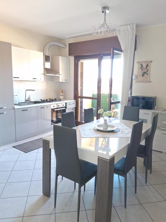 a kitchen with a table and chairs and a kitchen with white cabinets at Casa di Stefy in Quartu SantʼElena