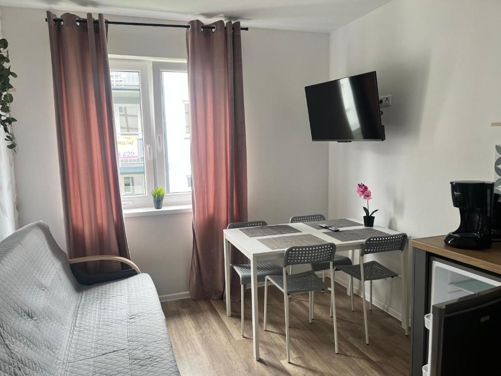 a living room with a table and chairs and a tv at Apartament 44A Dębina I 400 m do plażyl przyjazny rowerzystom in Debina