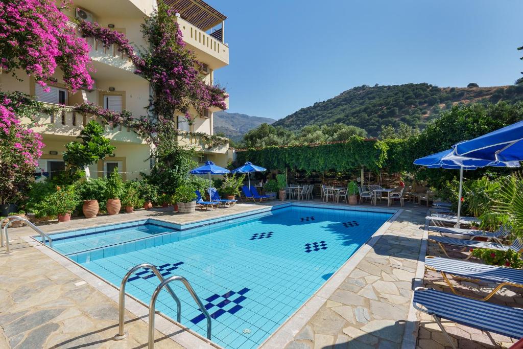 a pool at a hotel with chairs and umbrellas at Sunrise Hotel & Apartments in Rodakino