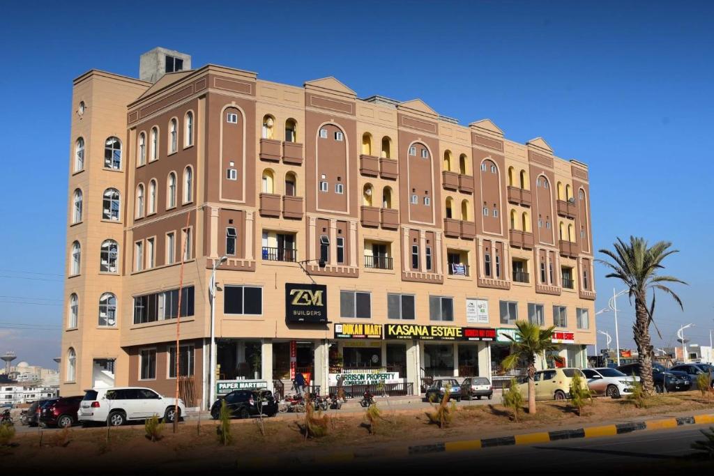 a large building with cars parked in front of it at Luxury 1BHK Apartment in Rawalpindi