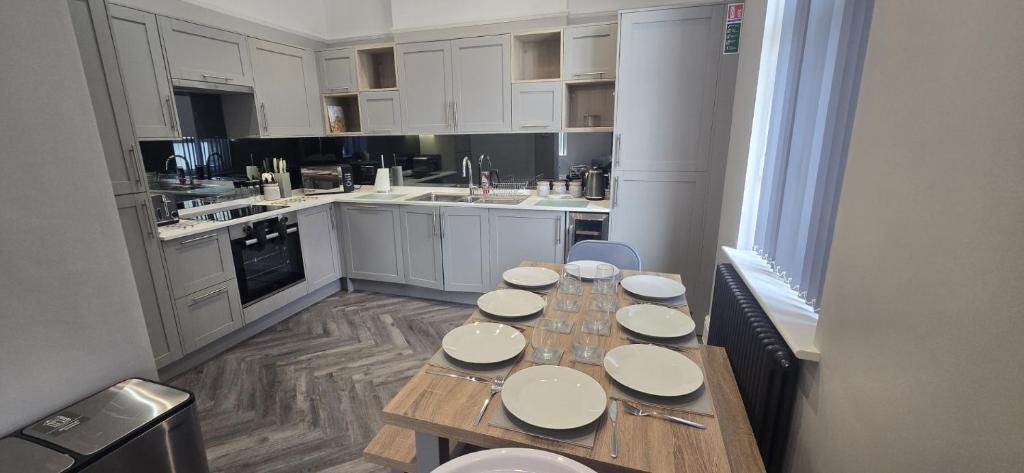 a kitchen with a wooden table with plates on it at Stylish 4 bed in Central Conwy in Conwy