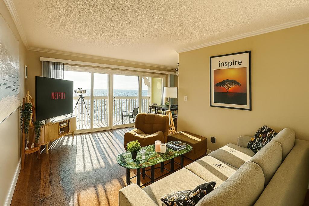 a living room with a couch and a tv at Ocean Haven Beachfront Getaway by Redondo Pier in Redondo Beach