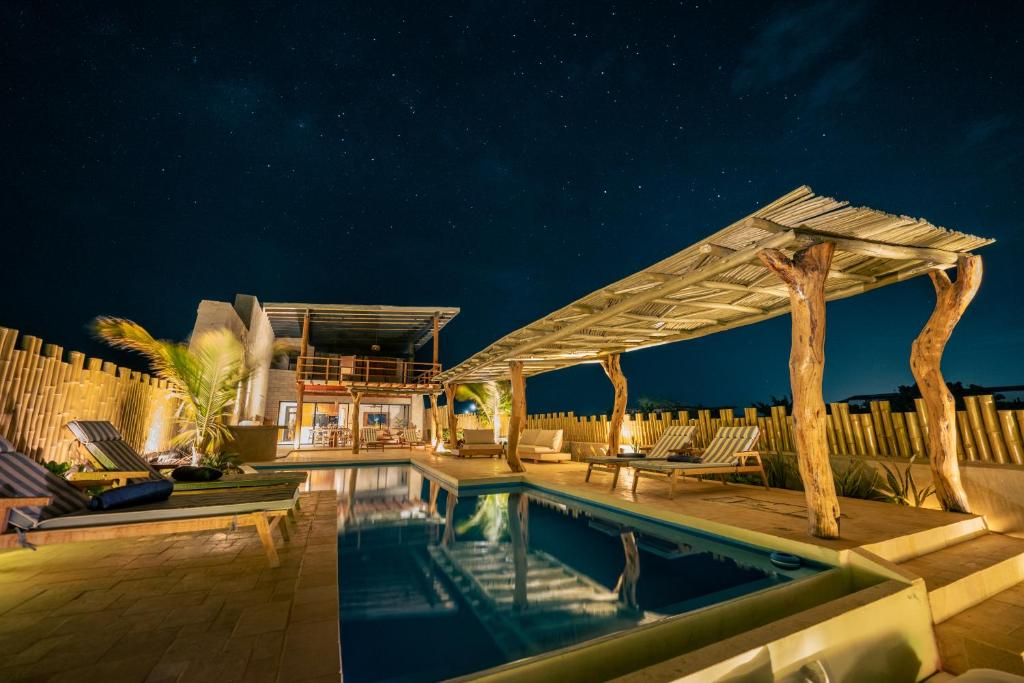 a house with a swimming pool at night at Aviva, brand new designer luxury villa in Vichayito