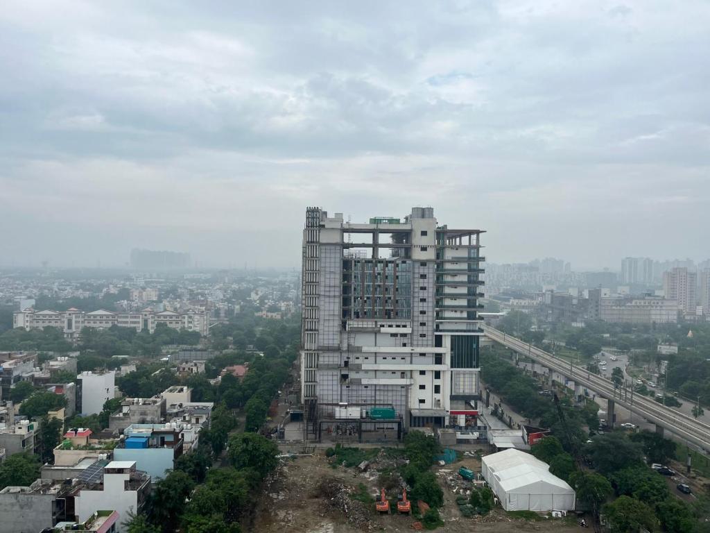 a tall building in the middle of a city at Nirvana by Urban Retreat Suite Near Expo Mart in Greater Noida