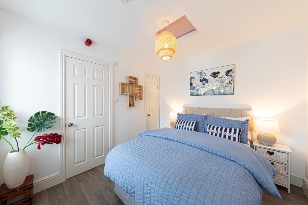 ein Schlafzimmer mit einem Bett mit einer blauen Bettdecke in der Unterkunft Sea Shore Apartment in Llandudno