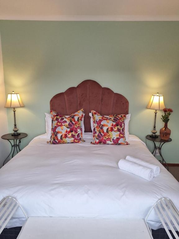 a bedroom with a large white bed with two lamps at Luxury suite near Church Street in Stellenbosch