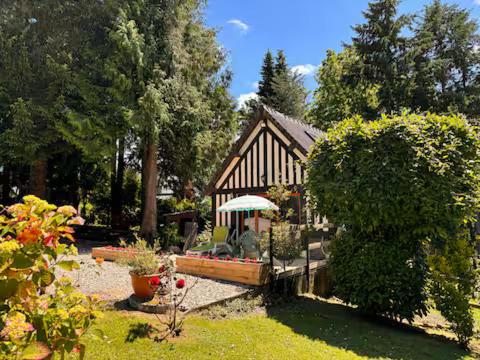 DanestalにあるGîte La Bakata à Danestal près de Deauvilleの庭にある傘のある小さな建物