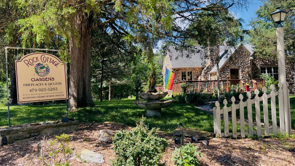 a white picket fence in front of a house at Rock Cottage Gardens B&B in Eureka Springs
