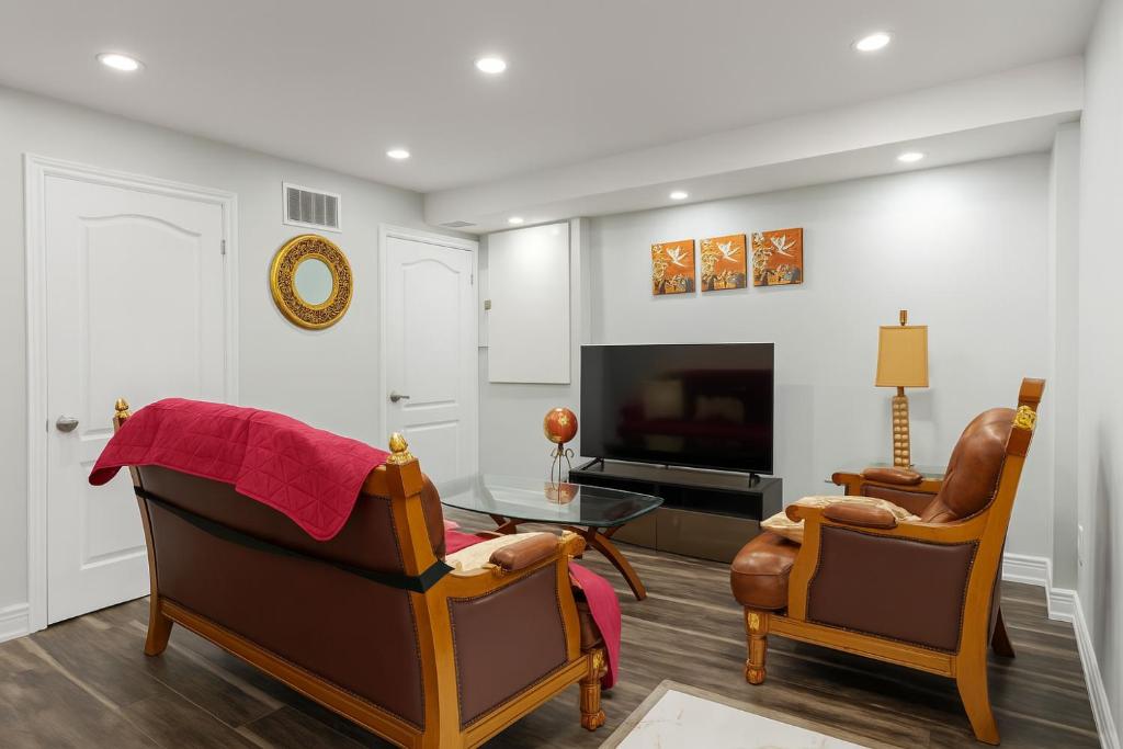 a living room with two chairs and a television at Newly Renovated 3BR Orangeville Basement Suite with Private Access, 10 Min Walk to Headwaters Hospital, 5 Min Drive to Mount Alverno Luxury Resorts, Ideal for Medical, Vacation or Work Stays! in Orangeville