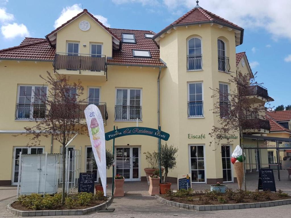 a yellow building with a sign in front of it at Karlshagen beach residence in Ostseebad Karlshagen