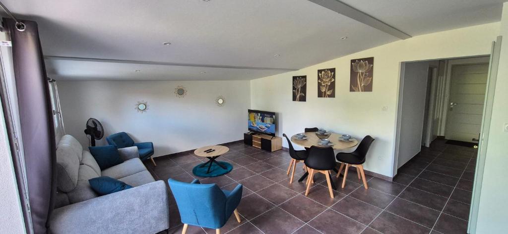 ein Wohnzimmer mit einer Couch und einem Tisch und Stühlen in der Unterkunft Maison plein coeur de village in Villevieux