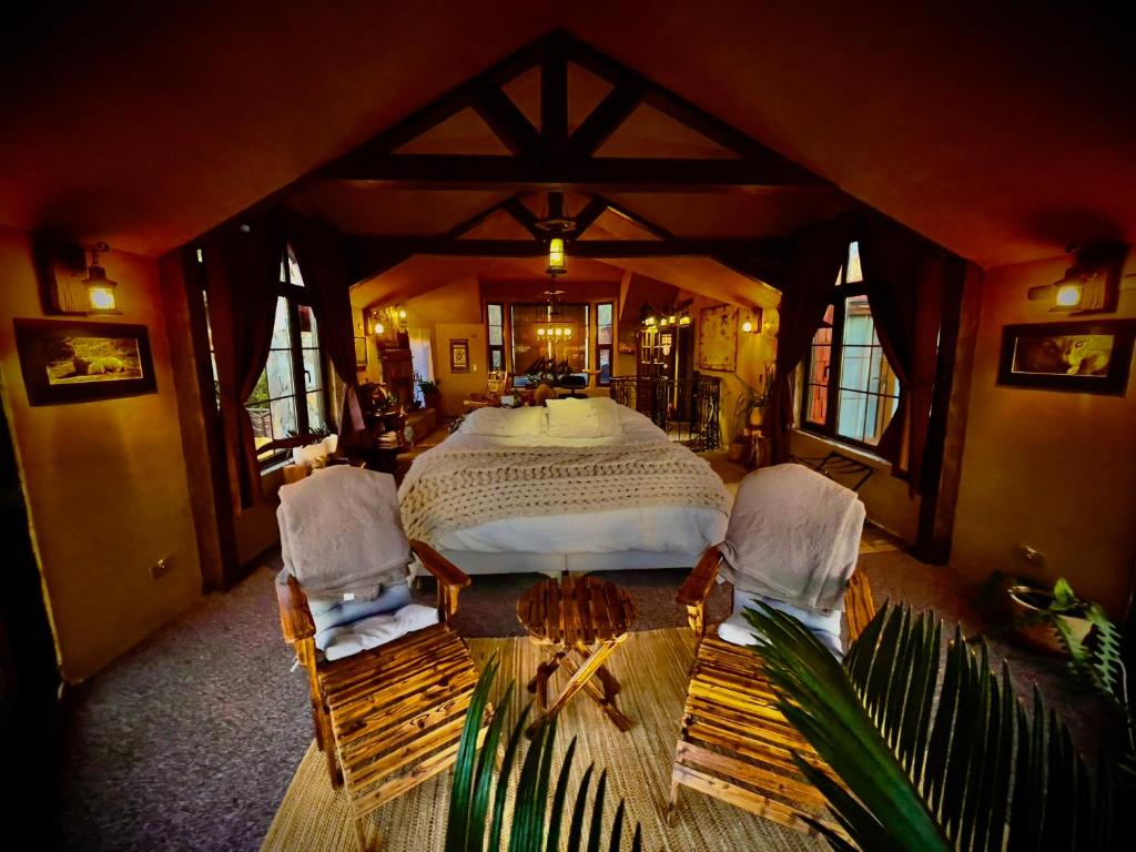 a bedroom with a large bed and two chairs at Loft in Patagonia Chiloe Island, Duhatao - Pumillahue in Ancud