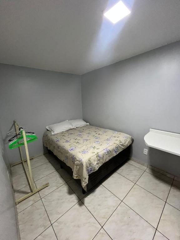 a small bedroom with a bed and a sink at Estúdio 101 - 10 minutos da rodoviária e aeroporto in Brasilia