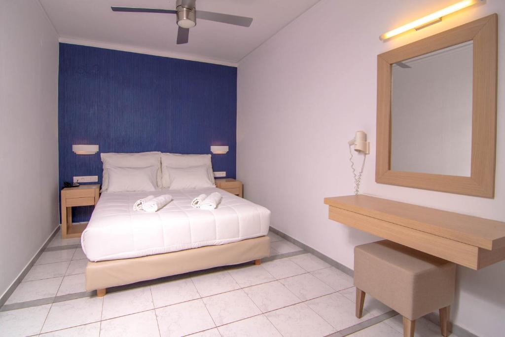 a bedroom with a white bed and a blue wall at Pal Beach in Palaiochora