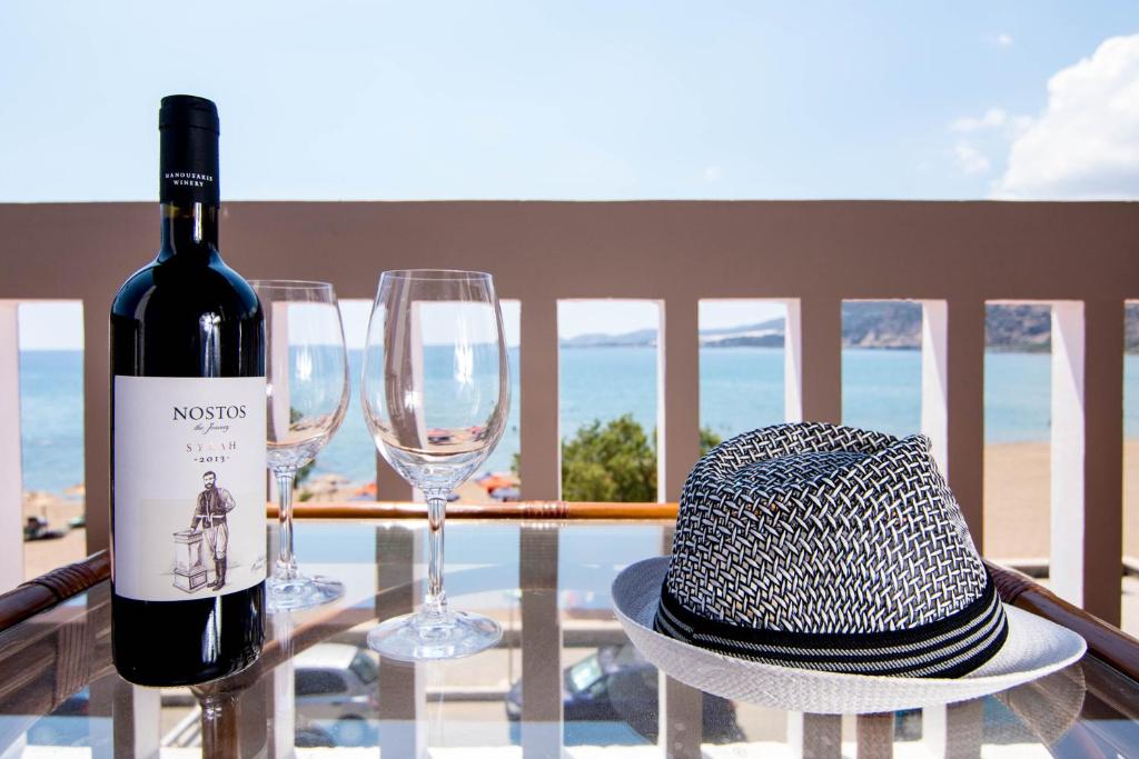 a bottle of wine and two glasses on a table at Pal Beach in Palaiochora