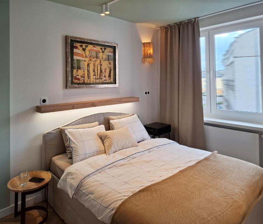 a small bedroom with a bed and a window at Boho Apartment - 100m from Market Square in Wrocław